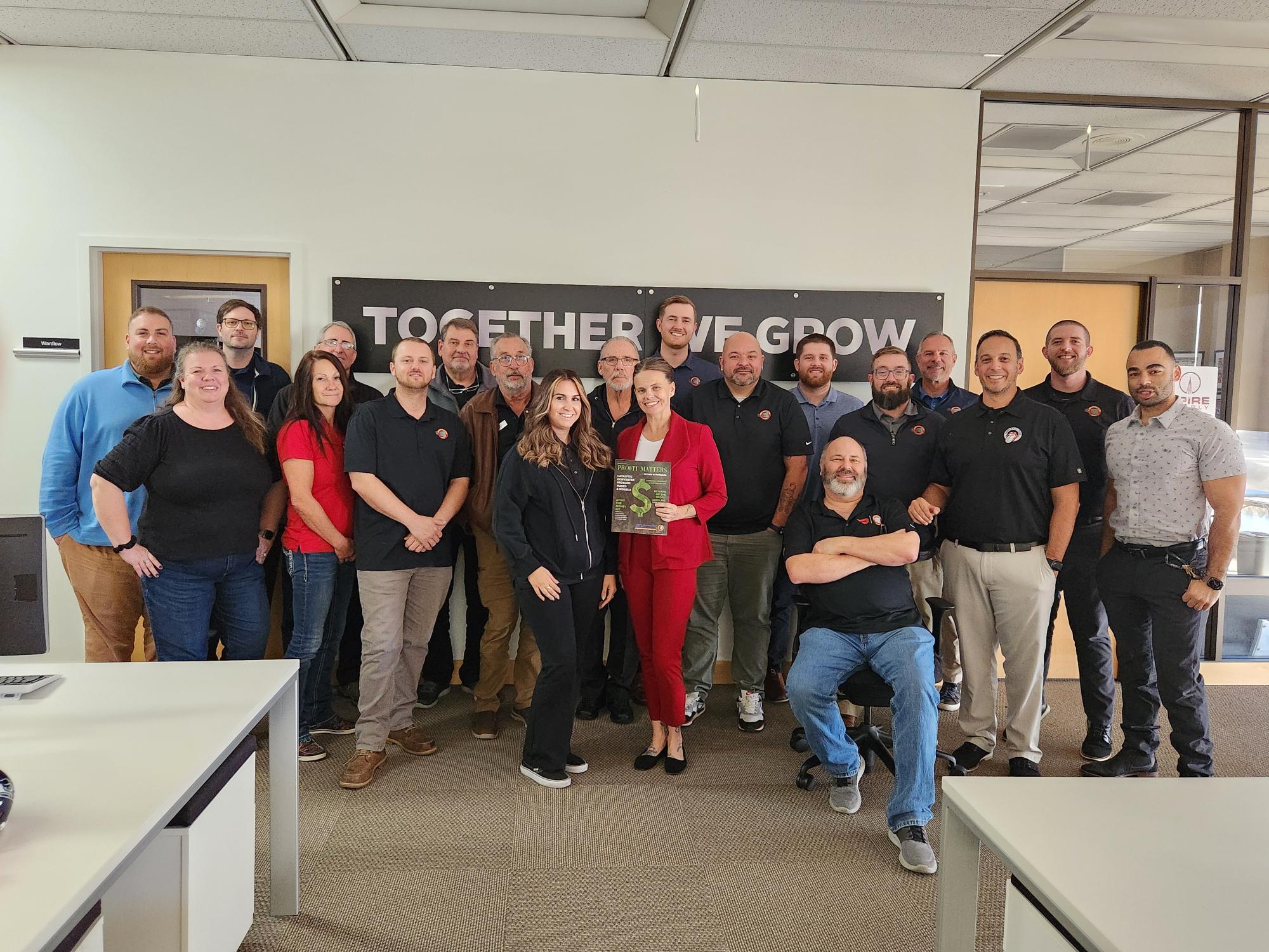 The Radiator team in the office in front of a sign that says Together We Grow.